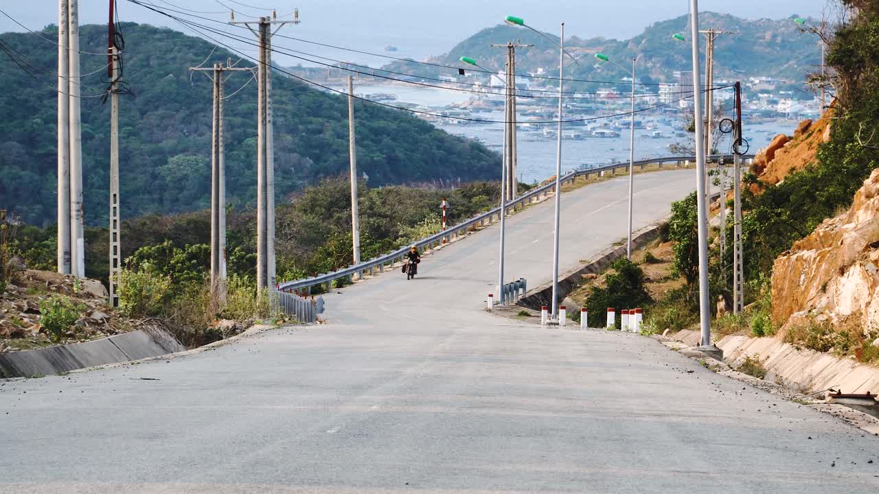 해변 도로에서 오토바이 여행, 백그라운드에서 베트남 해안 항구 마을