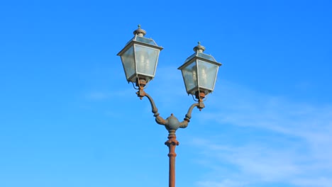 panning across typical italian street lamp on clear blue sky in naples, italy