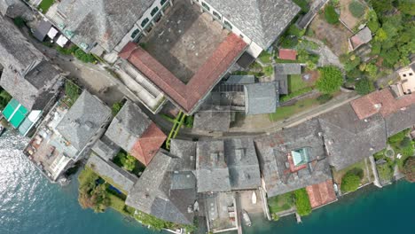 isola di san giulio en el lago orta, italia, con edificios históricos y aguas circundantes, vista desde arriba por un dron