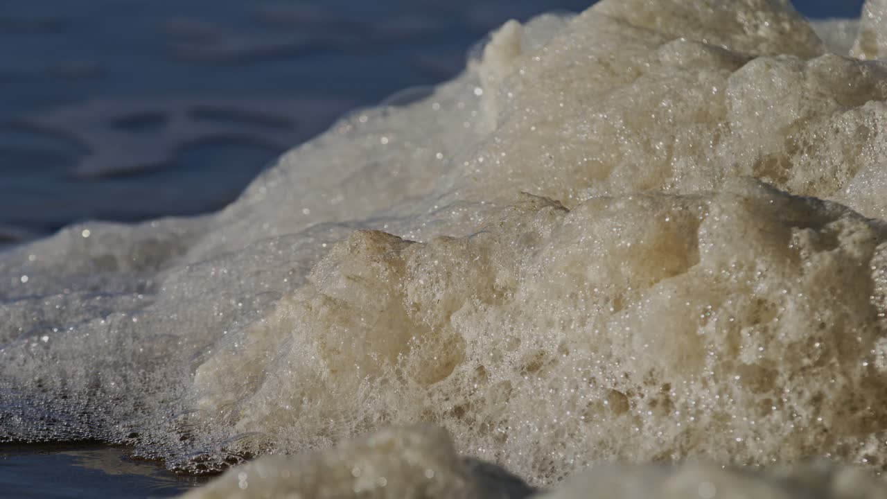 Soft, foamy waves near the Oosterschelde storm surge barrier in Zeeland
