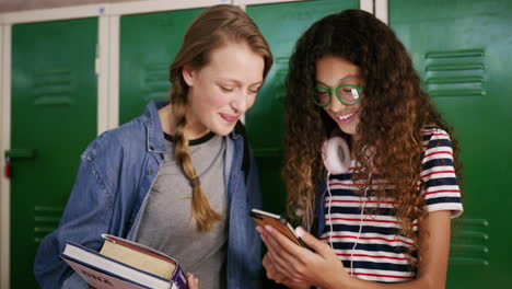 dos adolescentes usando un teléfono inteligente juntos