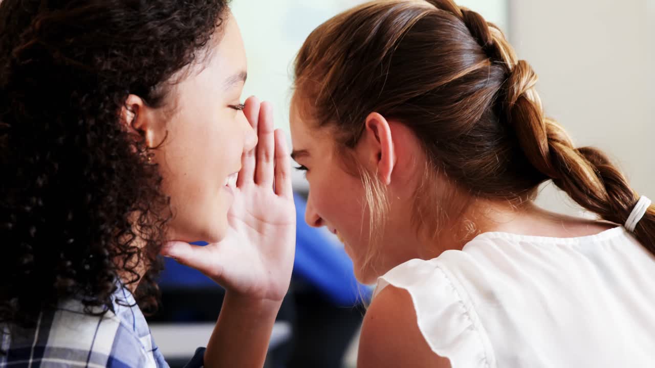 estudiantes chismoseando durante la clase en el aula