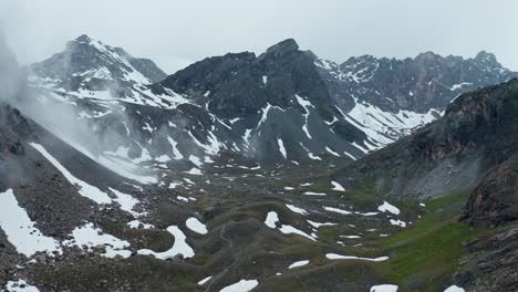 Paisaje-Montañoso-Brumoso-Con-Parches-De-Nieve-Y-Cascata-Di-Stroppia,-Lago-Niera-Visible