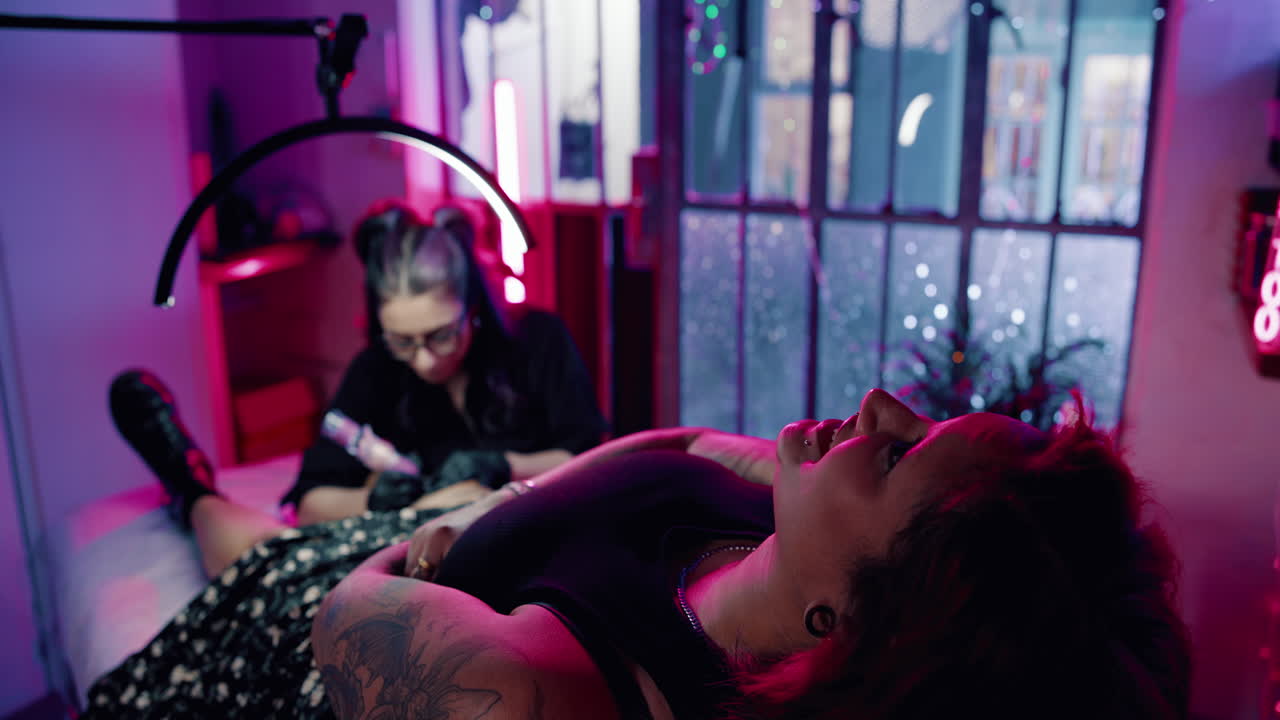 Tatoveringsøkt i et neonbelyst studio