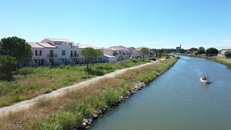 Barco-De-Recreo-En-Un-Canal-En-Aigues-Mortes-Al-Sur-De-Francia-Vista-Aérea-Día-Soleado