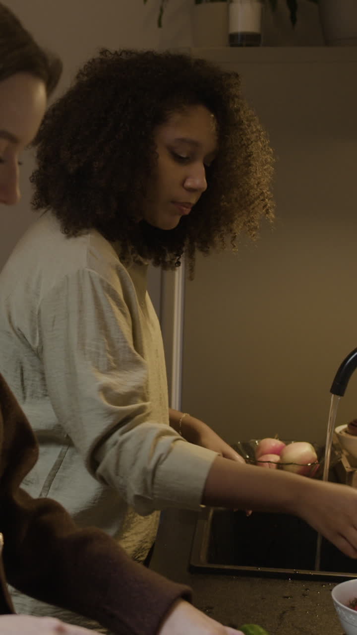 Woman Washing Vegetables in the Kitchen Sink