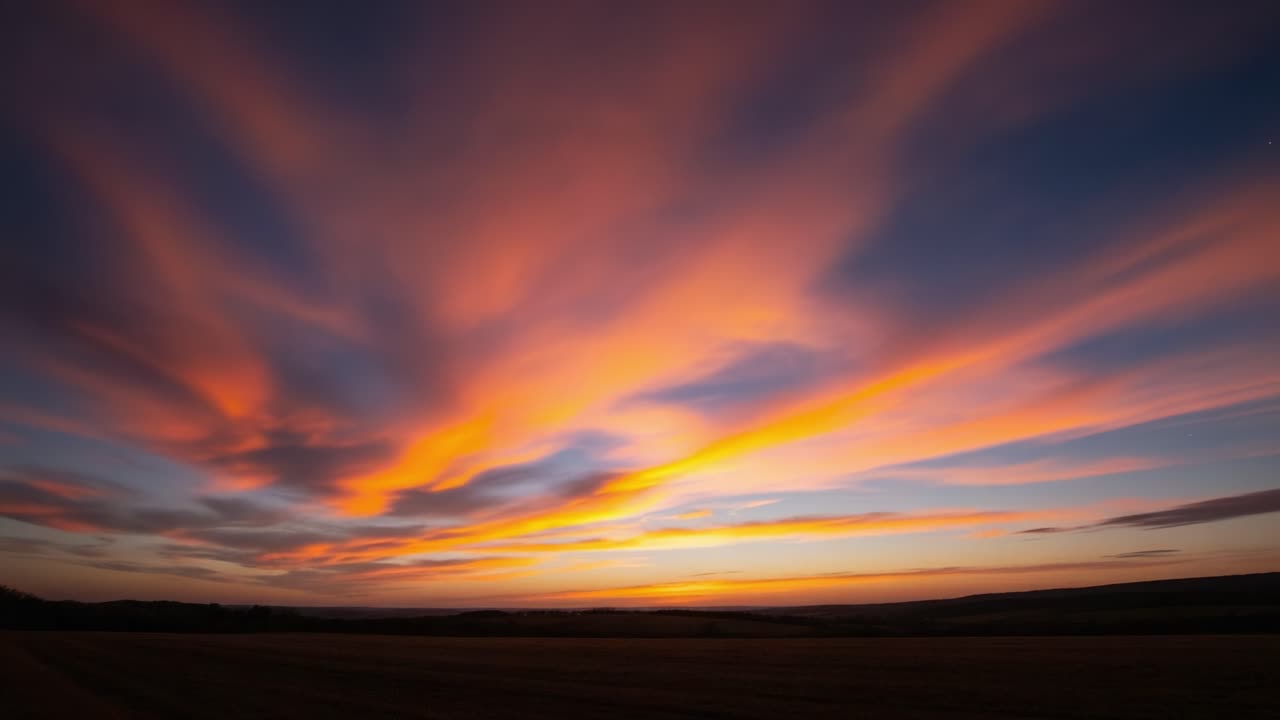 Vibrant Streaked Clouds at Sunset Over a Landscape