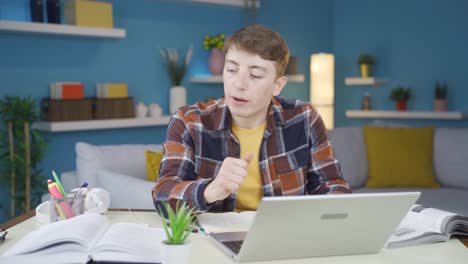 Student-doing-homework-looks-at-laptop-with-negative-expression.