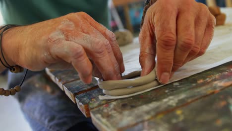 mid section of artist molding clay at table 4k