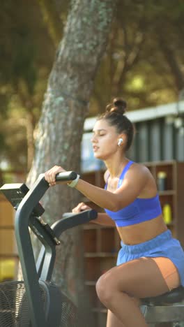 Woman exercising outdoors on a stationary bike