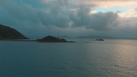 Volando-Hacia-Una-Isla-Durante-La-Puesta-De-Sol-En-Una-Tarde-Nublada