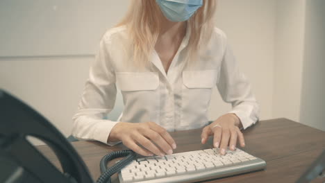 close up of youn woman with face mask having a business call in the office