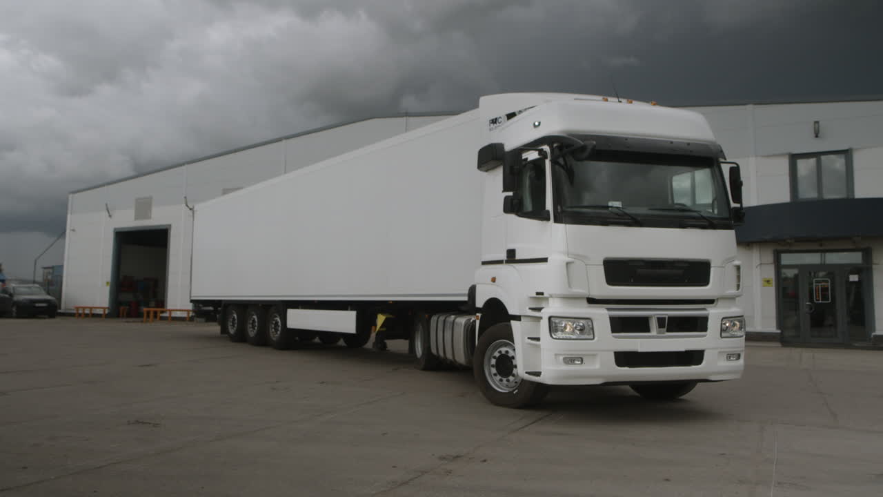 A white semi-trailer truck parked in a lot