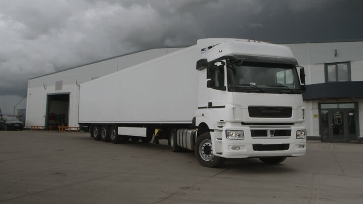 A white semi-trailer truck parked in a lot