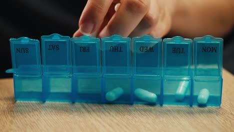 persona que utiliza un organizador de pastillas semanal