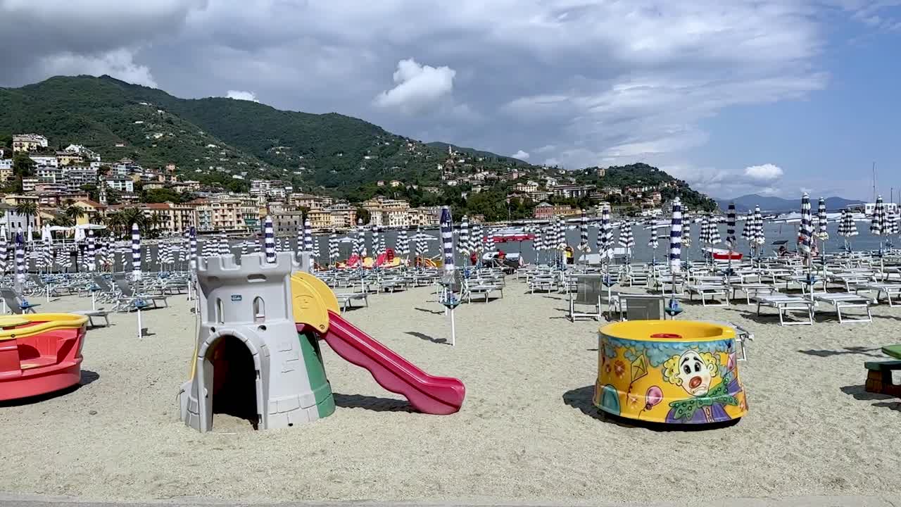 Beach Flora and Lido, Rapallo in Italy, sandy beach with children's playground, sun loungers, sunbrellas etc