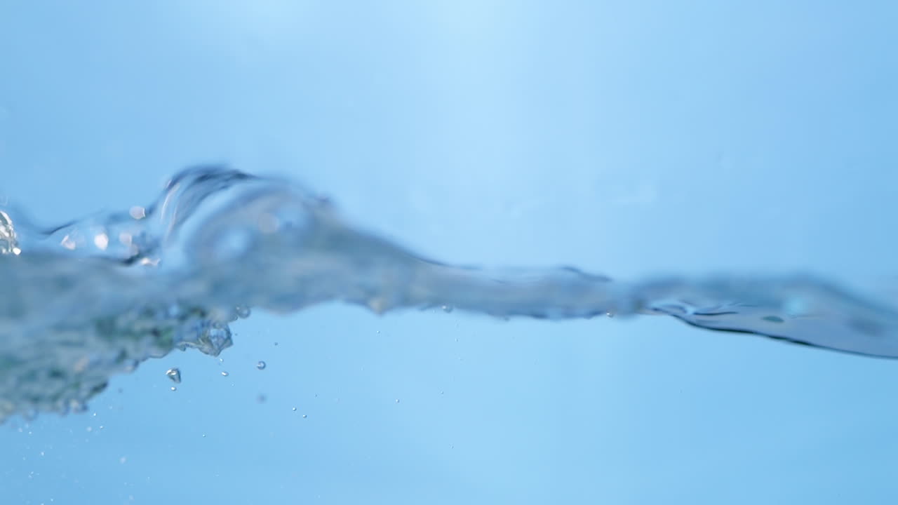 Stunning close-up shot of clean water surface in slow motion, featuring vibrant blue waves that symbolize purity and freshness for beverage-related content.