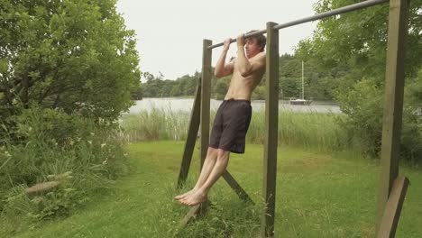 an athletic young man performs close grip chin-ups