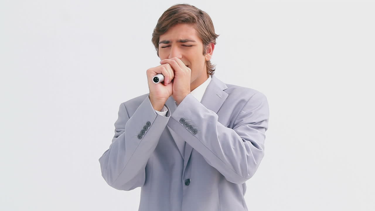 행복한 경영자가 무선 마이크로 노래하고 있습니다.