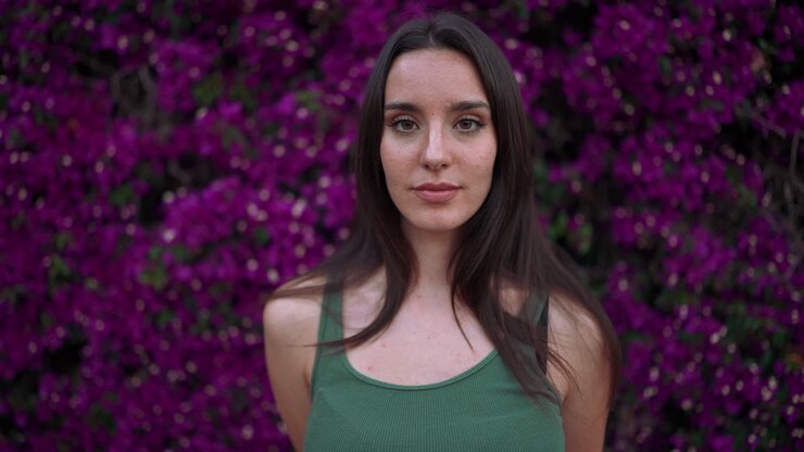 Mujer posando delante de flores moradas