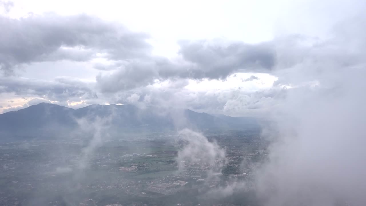 video desde arriba. vista aérea de un dron volando a través de algunas nubes. campo italiano en el fondo.