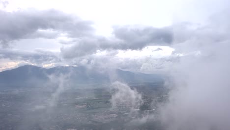 video from above. aerial view of a drone flying through some clouds. italian countryside on background.