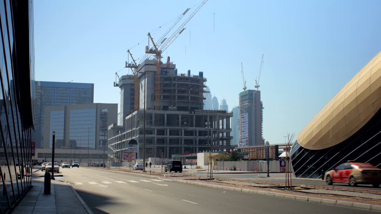construcción de edificios en el centro de dubai cerca del metro, vista en un día soleado desde la carretera