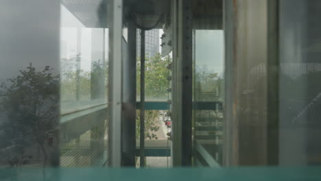 reflections in glass as elevator descends urban setting