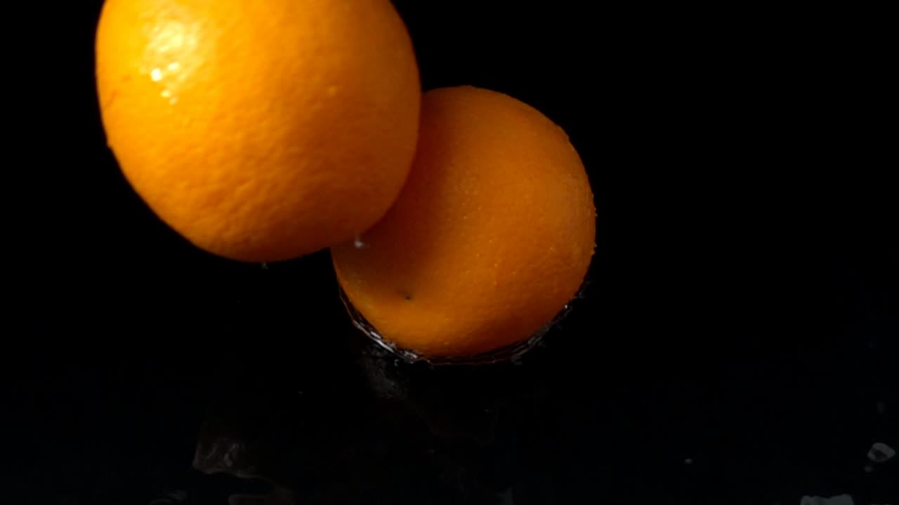 Caduta di arancia in acqua. Slow motion