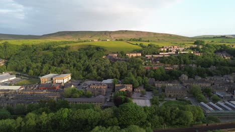 short fly over todmorden town center showcasing tree tops and old rural buildings