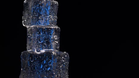 close up ice cubes rotating on black background