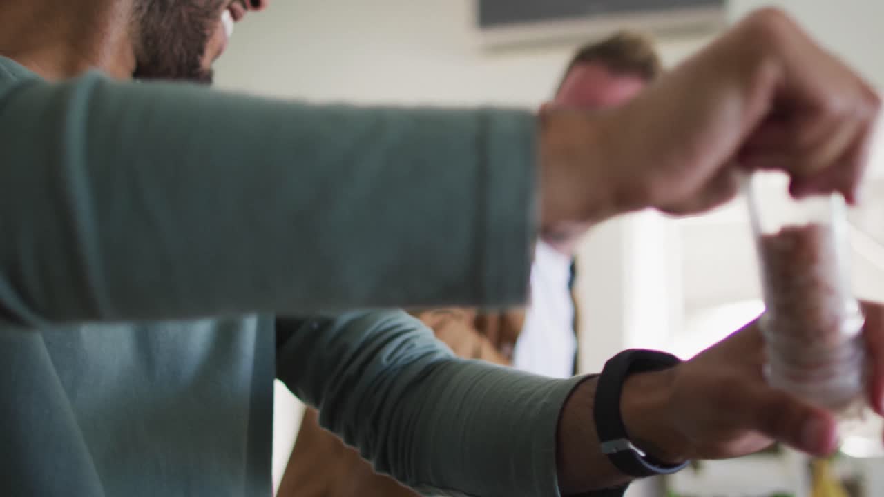 pareja de hombres homosexuales multiétnicos preparando comida en la cocina
