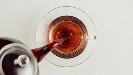pouring tea into a glass cup
