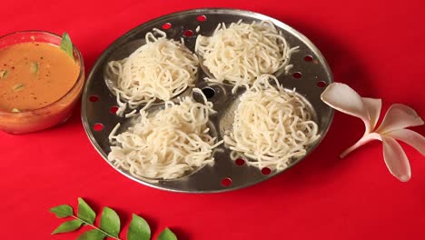 Idiyappam--String-Hoppers--Traditional-Kerala-Steamed-Breakfast-on-red-background