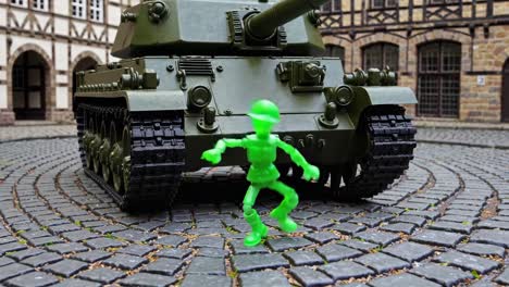 green plastic soldier in front of a tank in an old town square