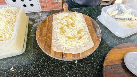 el queso se raspa a mano en una tabla de madera.