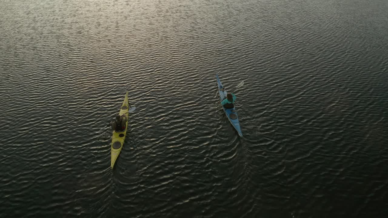 pareja remando kayac al atardecer