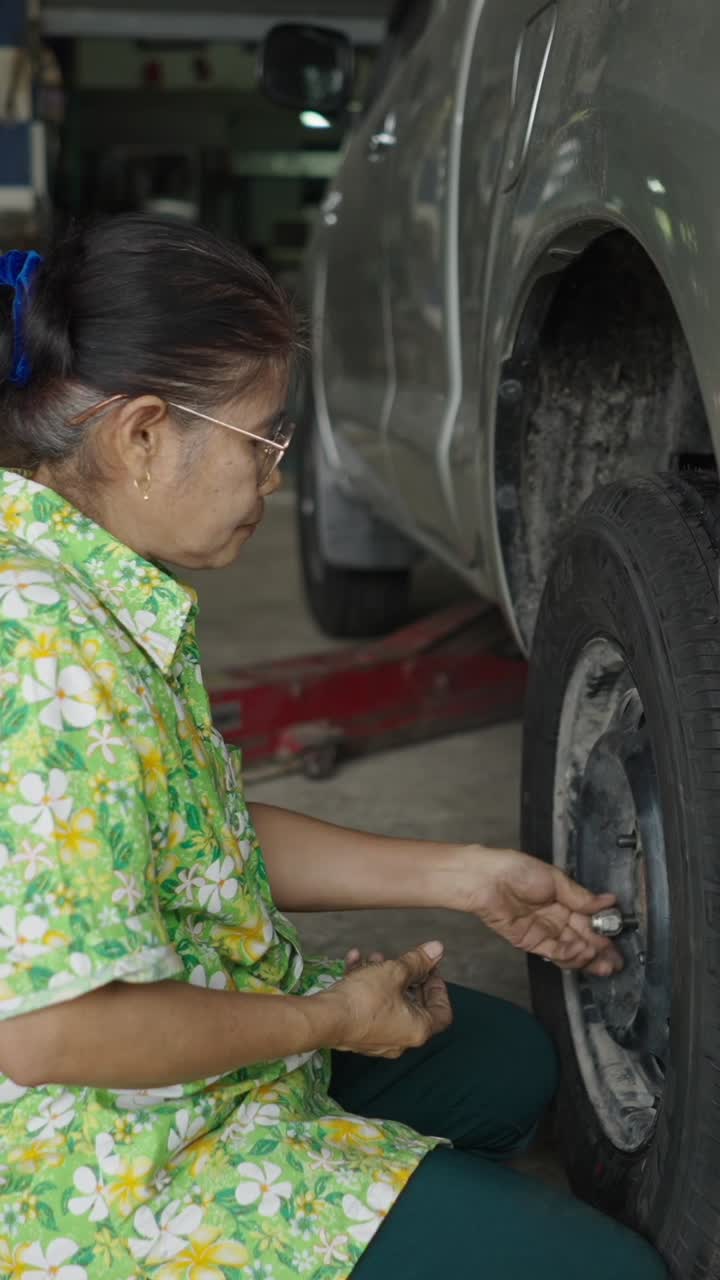Woman working on car tire