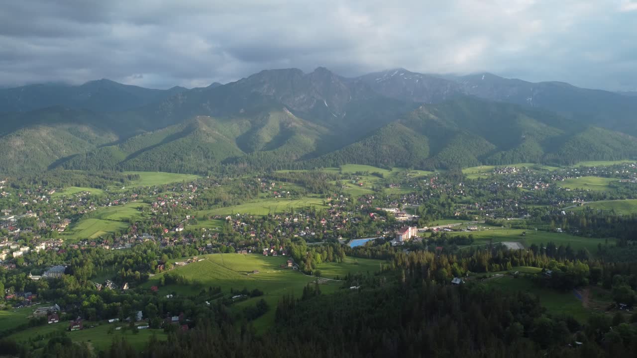 vista lejana del valle desde el paisaje de gubałówka sobrevuelo de las montañas tatry polacas cubiertas de nieve, tierras de cultivo, bosques y el legendario pico giewont cerca de zakopane, polonia - 4k 30fps rastreando hacia atrás