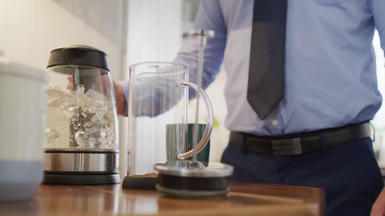 ⁇ 타이를 입은 백인 남자의 중간 부분, 부 ⁇ 에 서서 커피를 만드는