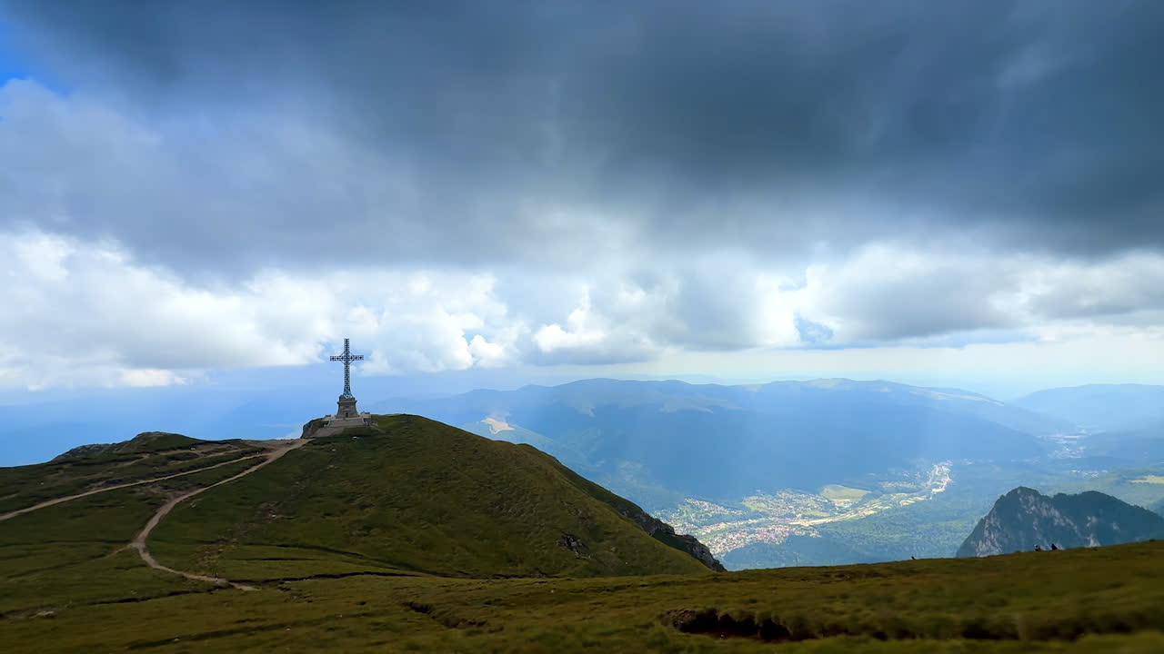 Caraiman Cross on Bucegi plateau with panoramic valley view. The Caraiman Cross monument on plateau ridge with mountains and valley panorama