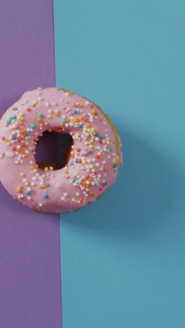 video of donut with icing on purple and blue background