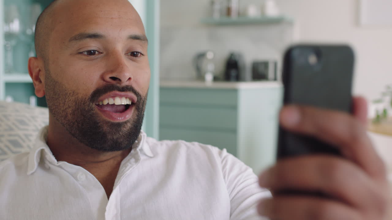 joven feliz hablando por video usando un teléfono inteligente saludando a su bebé sonriendo padre saludando con la mano disfrutando de hablar por teléfono móvil en casa
