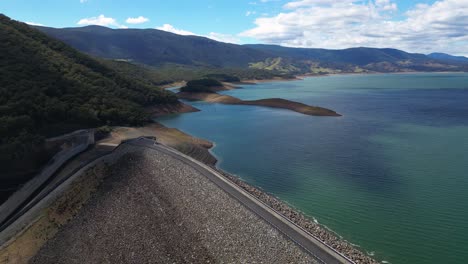 left to right aerial views over the blowering dam, spillway and reservoir, new south wales alpine region.