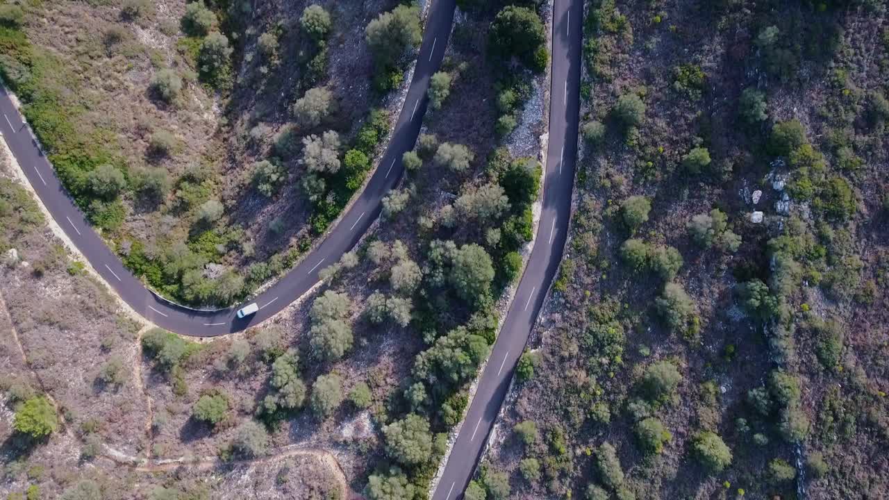 toma de arriba hacia abajo en 4k de conducción de automóviles a través de serpentinas en un día soleado - peligrosa carretera de montaña desde arriba