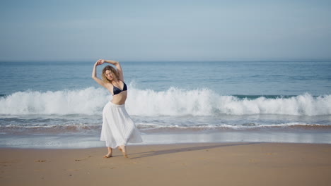 romantic girl performing dance on beautiful sand beach. choreographer dancing