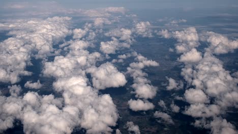 aerial footage shot from high altitude plane with clouds spotted throughout as weather meteorological example