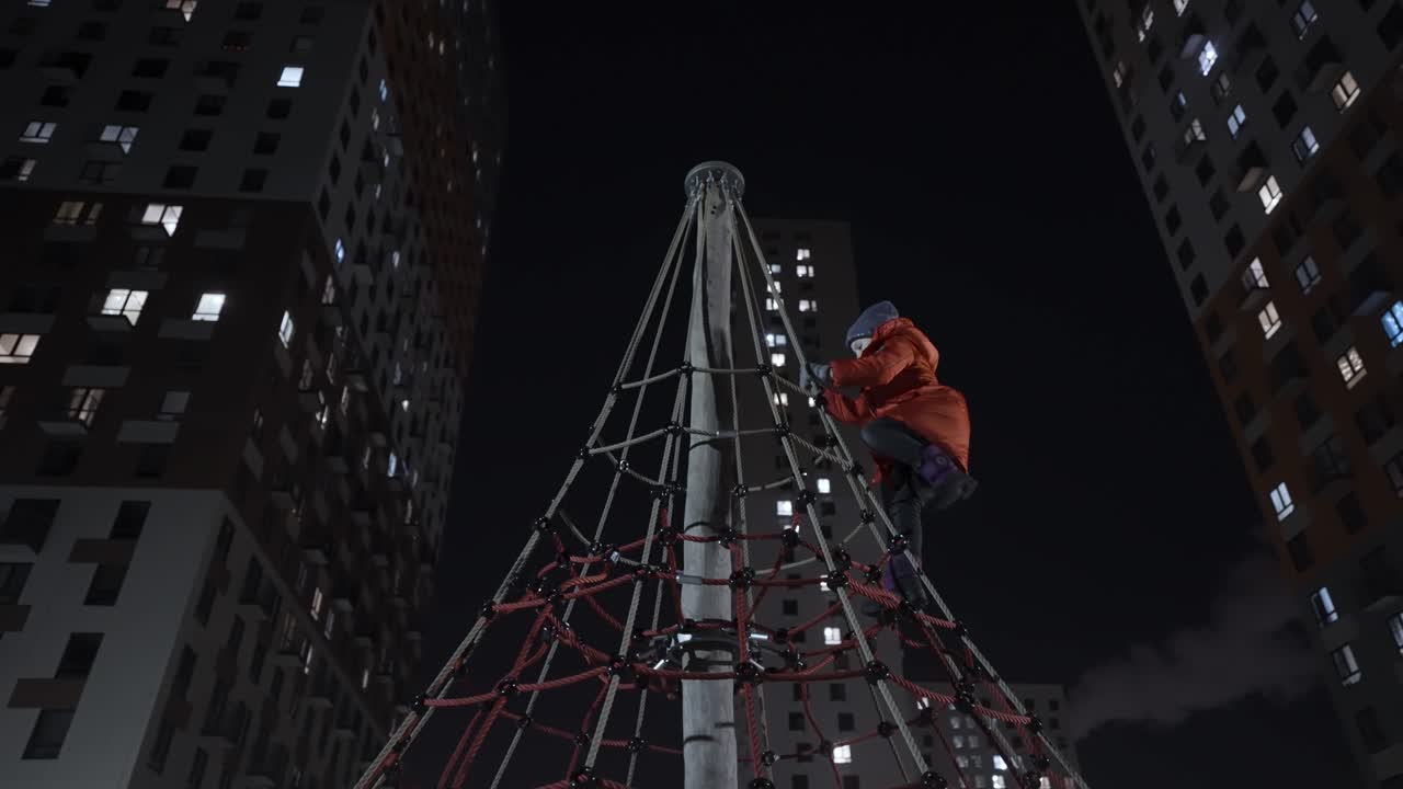 Child Climbing on a Playground at Night