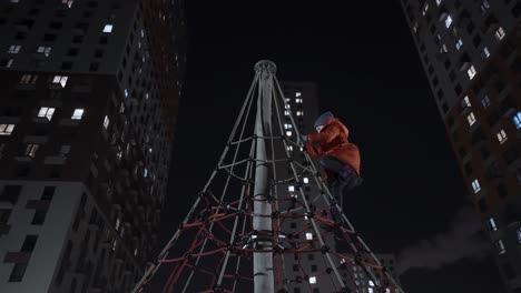 child climbing on a playground at night