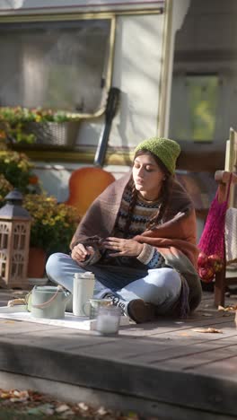 woman enjoying a warm drink outdoors in a camping trailer